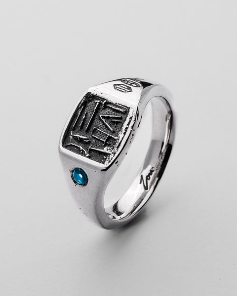 Workshop Signet in sterling silver — angled front showing stamped face and blue stone
