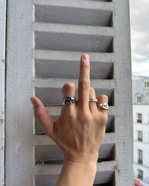 Gun Ring in sterling silver — worn with other silver rings beside window shutters