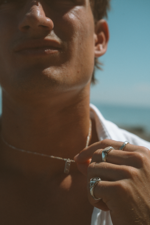 Lou's Stacker in sterling silver — worn with mixed silver rings in a sunlit portrait