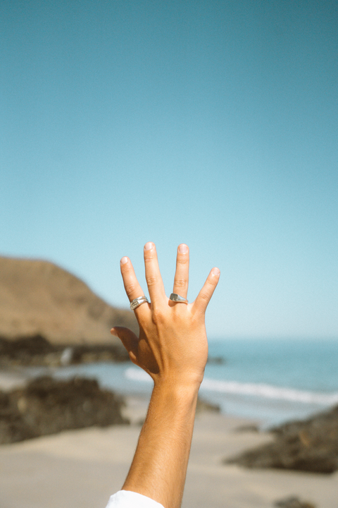 Cliffside Signet in sterling silver — worn with another silver ring beside the ocean