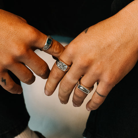 Nascence frangipani ring in sterling silver — close-up worn among multiple rings