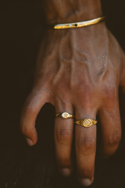 Plumeria ring in 24ct gold plate — worn with an ornate signet and gemstone cuff