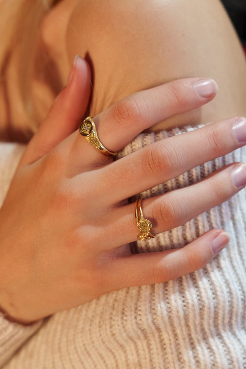 Petals ring in 24ct gold plate — worn with a gold signet in a close-up hand portrait