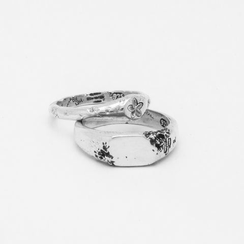 Plumeria ring in sterling silver — displayed above a wider silver floral signet