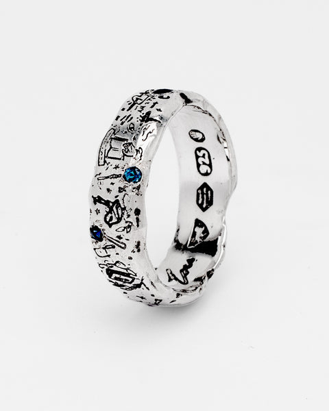 Lou's Grad Ring in sterling silver — angled side view showing blue gemstones and 925 mark