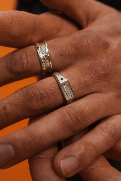 Feather Signet in sterling silver — worn close-up with the feather engraving visible