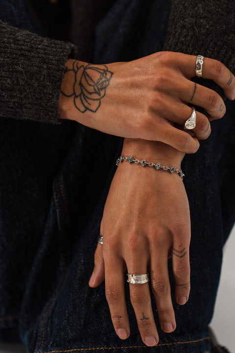 Signature Bracelet in sterling silver — worn on the wrist with the flower links visible