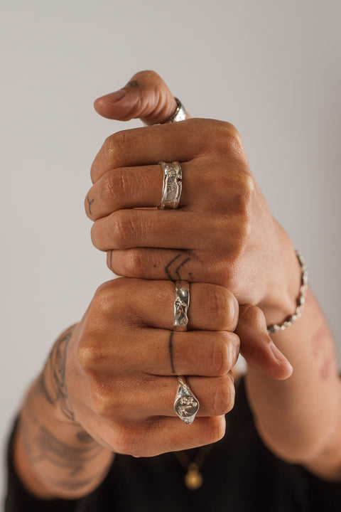 Vivid ring in sterling silver — worn with mixed silver rings in a two-hand portrait