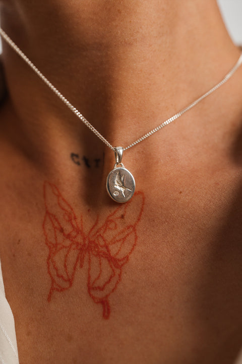 Family Pendant in sterling silver — close-up worn on the chest showing the oval face