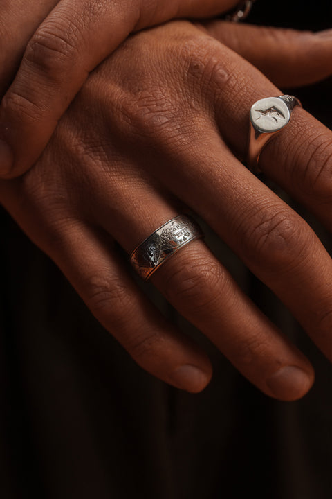 The Grad Ring in sterling silver — worn beside a silver signet with the engraving visible