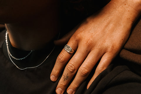 Nascence frangipani ring in sterling silver — worn near the chest beside a necklace