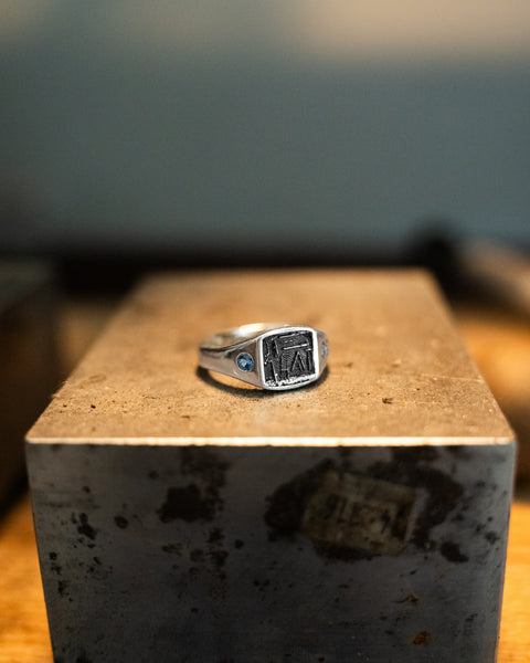 Workshop Signet in sterling silver — displayed on a steel block in the workshop